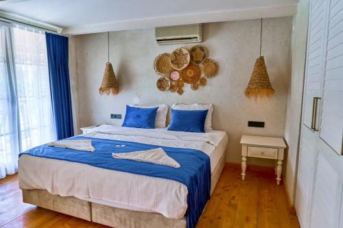 a bedroom with a large bed with blue sheets at Salonika Suites in Oludeniz
