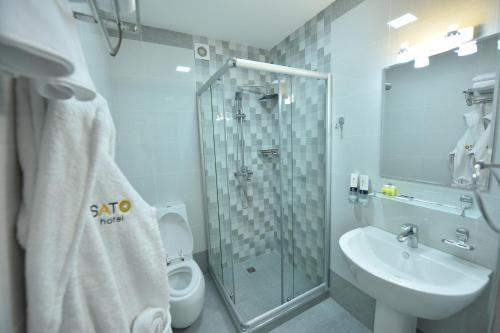 ein Bad mit einer Dusche, einem WC und einem Waschbecken in der Unterkunft SATO HOTEL TASHKENT in Taschkent
