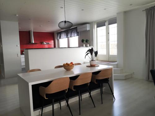 a kitchen with a white table and chairs at The HOME of Hiisi in Nummela
