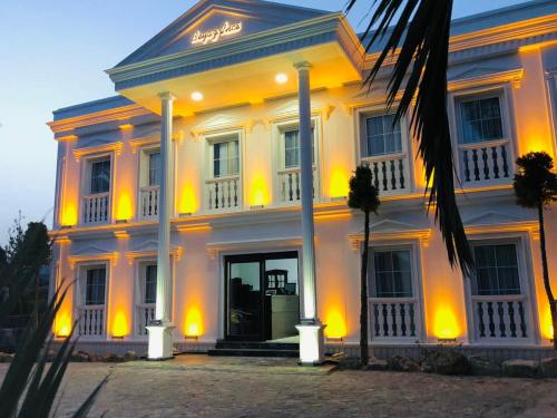 a large white building with yellow lights on it at Otel Beyaz İnci in Palamutbuku