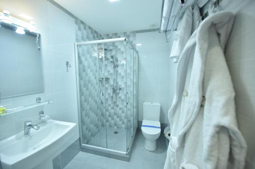 La salle de bains est pourvue d'une douche, de toilettes et d'un lavabo. dans l'établissement SATO HOTEL TASHKENT, à Tachkent