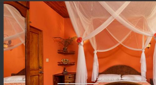 a bedroom with a bed with a white canopy at Effie Mountain View coco villa in Mahe