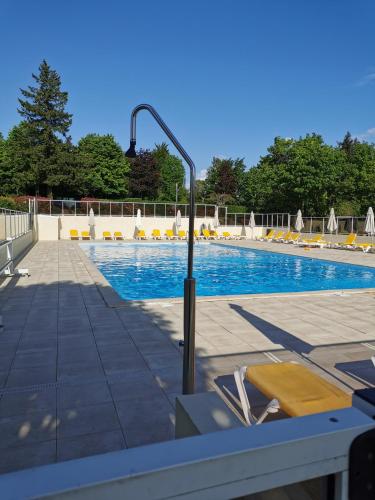 - une piscine avec des chaises et un pôle de lumière dans l'établissement l'atelier des reves, à Écuras