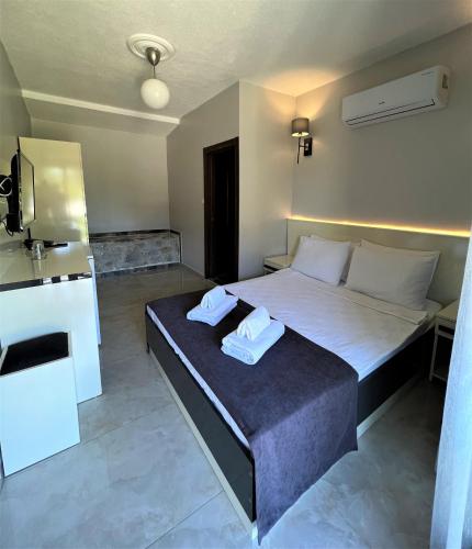 a bedroom with a bed with two towels on it at Otel Beyaz İnci in Palamutbuku