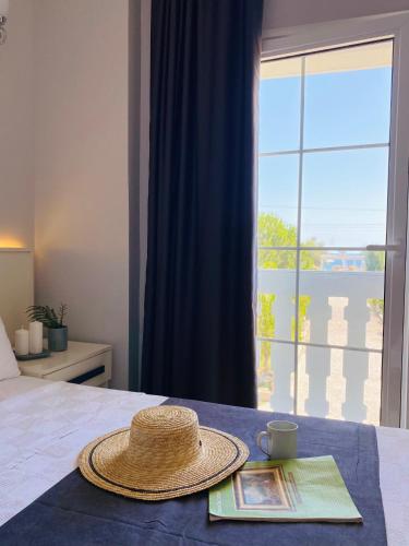 a straw hat sitting on top of a bed with a window at Otel Beyaz İnci in Palamutbuku