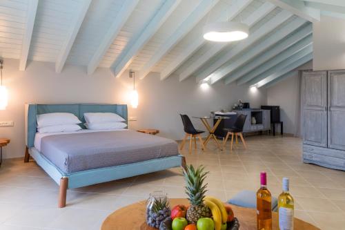 una camera con letto e tavolo con frutta e bottiglie di vino di Luxury Villa Matzourana by PosarelliVillas a Gardeládes