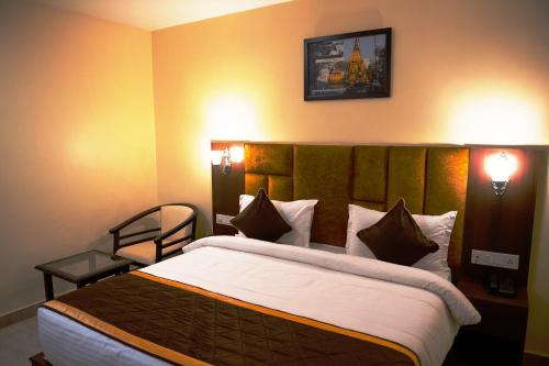 a hotel room with a large bed and two lights at HOTEL SHIVOY GRAND in Varanasi