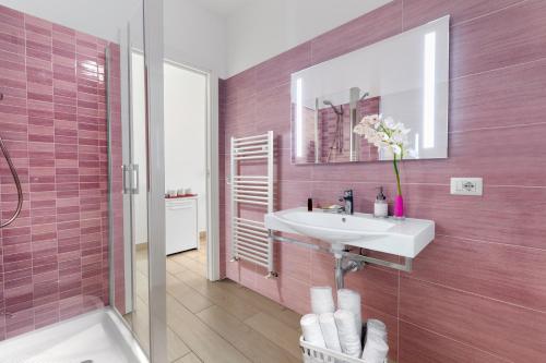a pink bathroom with a sink and a shower at Eterea Charming Suites in Sorrento
