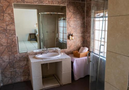 a bathroom with a sink and a mirror at Lions Rock Rapids - Lodge in Hazyview
