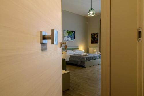a door leading to a bedroom with a bed at Bee Happy - Bed and Breakfast in Zafferana Etnea