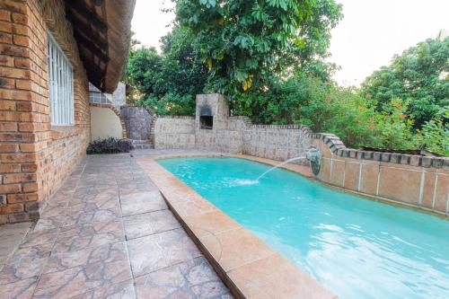a swimming pool with a water fountain at Lions Rock Rapids - Lodge in Hazyview