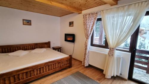 a bedroom with a bed and a large window at La Vulturi in Fundata