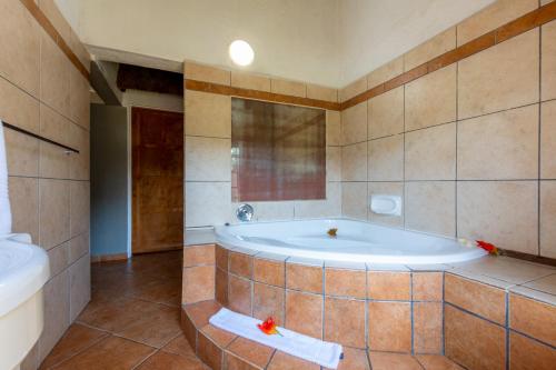 a large bathroom with a tub and a sink at Lions Rock Rapids - Lodge in Hazyview