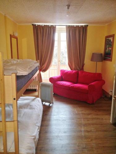 a living room with a red couch and a bunk bed at Maloja Palace Suites CO2-Neutral in Maloja