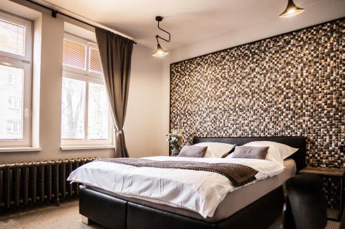 a bedroom with a large bed and a wall covered in wallpaper at Pension Padre in Ostrava