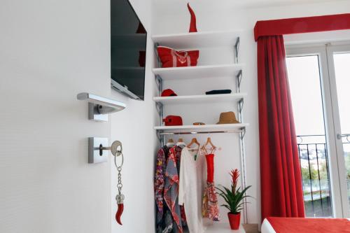 a room with white shelves and red curtains at Eterea Charming Suites in Sorrento