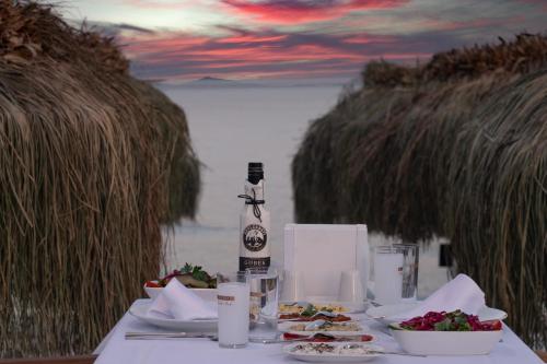 a table with plates of food and a bottle of wine at Otel Beyaz İnci in Palamutbuku