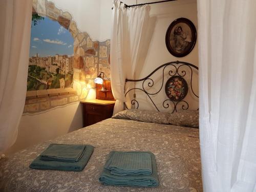 um quarto com uma cama e uma janela grande em Francy&Francy Apartment em Pitigliano
