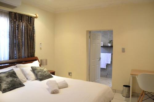 a bedroom with a bed and a bathroom at Hush Guest House in Northam