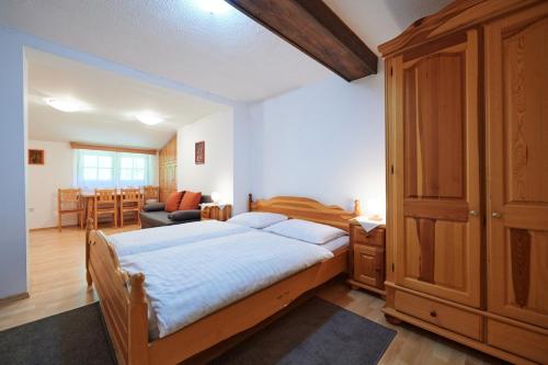 a bedroom with a large bed and a living room at Turistična kmetija Stoglej in Luče
