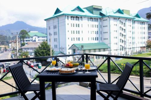 a table with food and drinks on a balcony at Cottage 42 in Nuwara Eliya