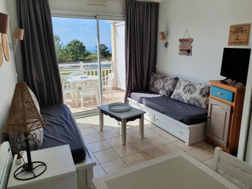 d'un salon avec un canapé et un balcon. dans l'établissement Appartement vue mer en residence piscines, à Les Sables-dʼOlonne