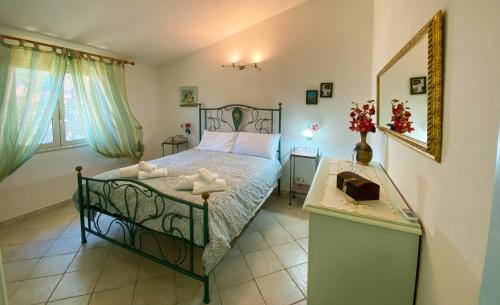 a bedroom with a bed and a table with a mirror at Santu Juanne -Ammentos Posada- a due passi dalla spiaggia in San Giovanni