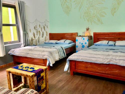 ein Schlafzimmer mit 2 Betten und einem Tisch darin in der Unterkunft Amazing House in Buôn Ðũng