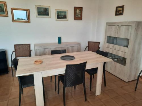Casa di Max في توري ديل أورسو: طاولة وكراسي خشبية في الغرفة