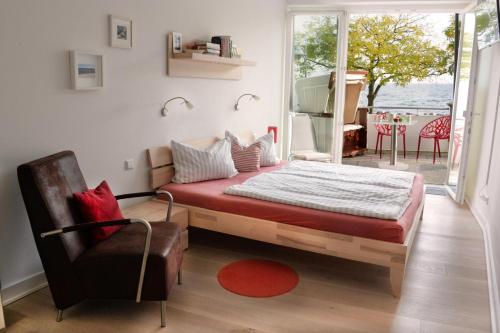 ein Schlafzimmer mit einem Bett, einem Stuhl und einem Fenster in der Unterkunft Ostseeresidenz Strandpromenade - Ferienwohnung "Ostseebrise" in Sassnitz
