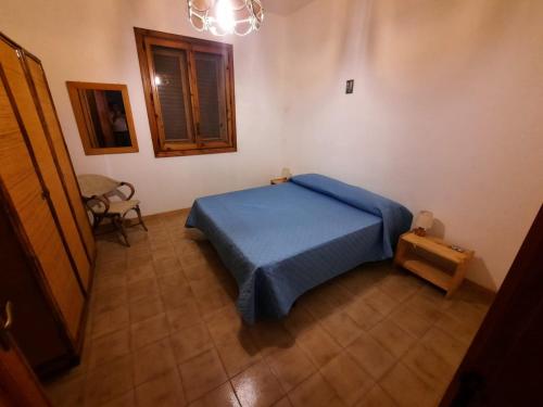 Un dormitorio con una cama azul y una ventana en Casa di Max, en Torre dell'Orso