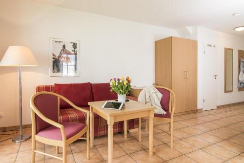 a living room with a couch and a table and chairs at Ferienwohnungen in der Ferienanlage Kap Arkona in Putgarten