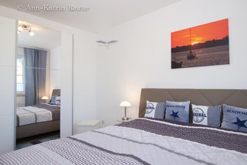 Schlafzimmer mit einem Bett mit blauen und weißen Kissen in der Unterkunft Ferienwohnung Mee(h)rZeit in Breege