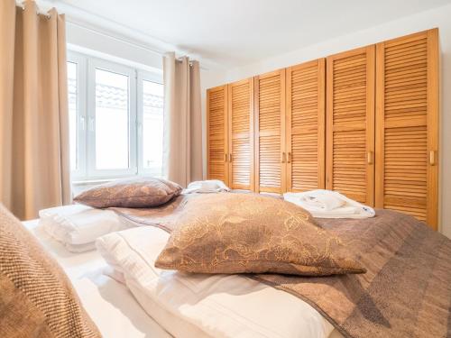 two beds in a bedroom with wooden cabinets at Ferienwohnung Naurulokki in Baabe