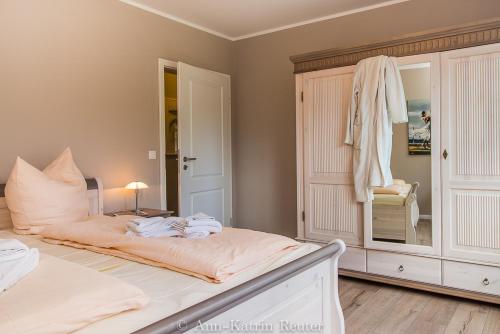 ein Schlafzimmer mit einem Bett mit einer Kommode und einem Spiegel in der Unterkunft Haus Meeresbrise - Ferienwohnung "Meeresrauschen" in Breege