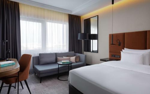 a hotel room with a bed and a couch at Radisson Collection Hotel, Warsaw in Warsaw