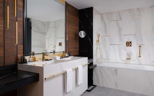a bathroom with a white sink and a mirror at Radisson Collection Hotel, Warsaw in Warsaw