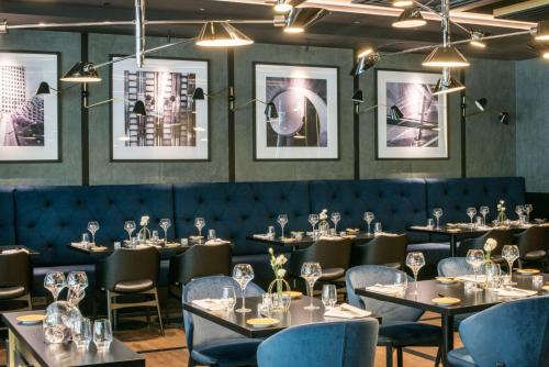 a dining room with tables and chairs and pictures on the walls at Radisson Collection Hotel, Warsaw in Warsaw
