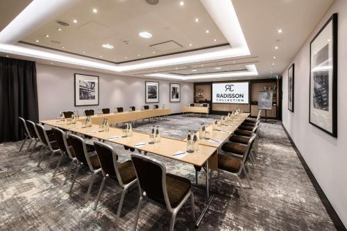 a conference room with a long table and chairs at Radisson Collection Hotel, Warsaw in Warsaw