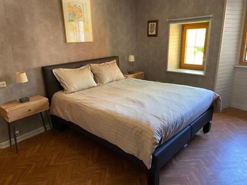 Un dormitorio con una cama grande con dos mesitas de noche. en Gite de la dime, en Ribeauvillé