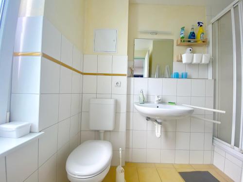 a white bathroom with a toilet and a sink at Wiek Hafenresidenz App 35 RZV in Wiek auf Rügen 