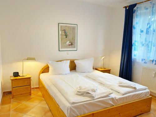 a bedroom with a bed with white sheets and a window at Sassnitz Villa Tizian Wohnung 9 RZV in Sassnitz