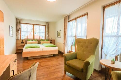 ein Schlafzimmer mit einem Bett, einem Stuhl und einem Tisch in der Unterkunft Hotel und Berggasthof Zum Sonnenhof in Sorge