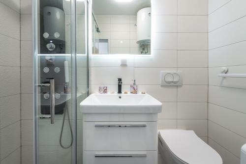 La salle de bains blanche est pourvue d'un lavabo et d'une douche. dans l'établissement Ana & Mia Apartment, à Dubrovnik