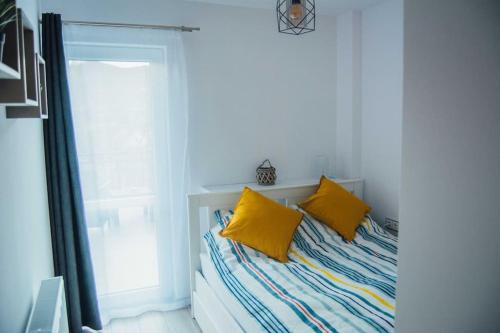 1 dormitorio con 1 cama con 2 almohadas amarillas en Rakoczi apartman 2 en Odorheiu Secuiesc