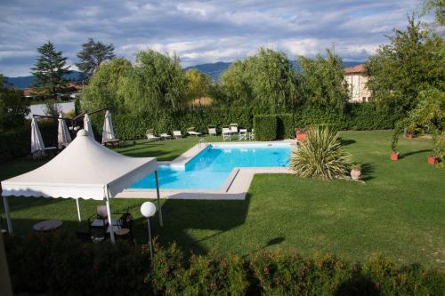 una piscina en un patio con una sombrilla blanca en Room in Farmhouse - Hortensia apartment en Chiesina Uzzanese