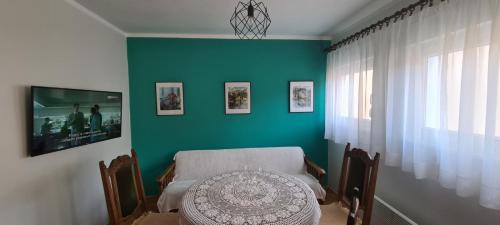 a dining room with a table and a green wall at Apartment City Heart in Trebinje