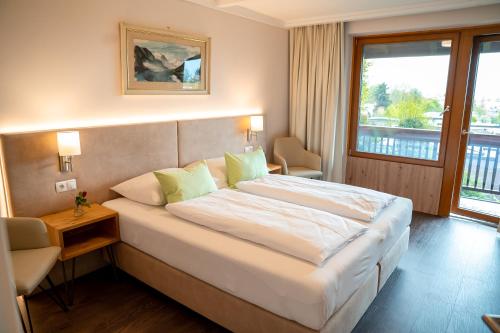 a hotel room with a large bed and a window at Hotel Garni Haus Arenberg in Salzburg
