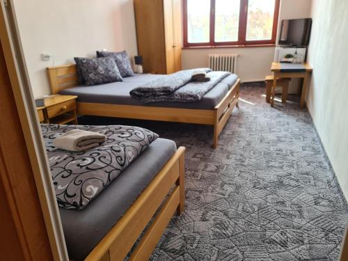 ロジュノフ・ポト・ラドホシュチェムにあるhotel KORUNAのベッド2台とテレビが備わる客室です。