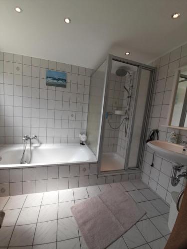 ein Bad mit einer Badewanne, einer Dusche und einem Waschbecken in der Unterkunft Ferienwohnung Familie Kluge in Jemgum